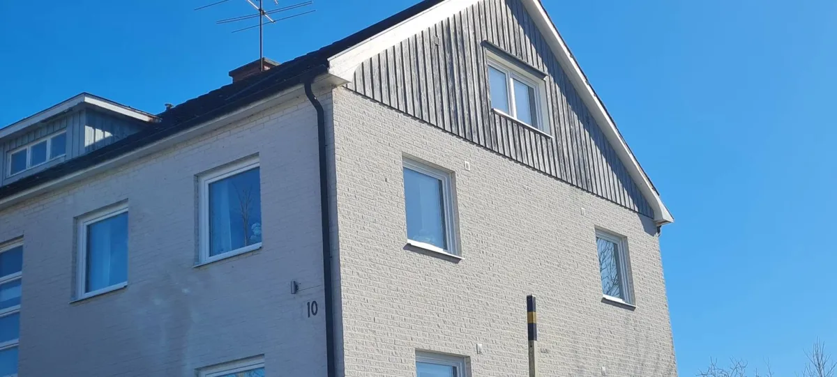 Samma gavel under arbetet, där tegelfasaden är klar men träpanelen fortfarande är den gamla